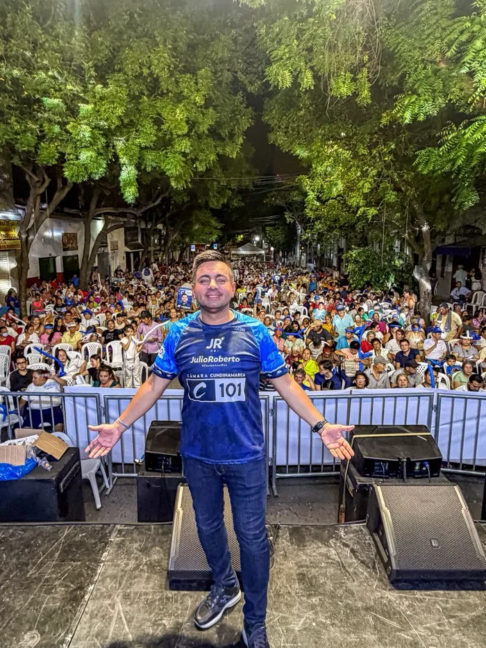 Julio Roberto abre los brazos en tarima frente a una multitud