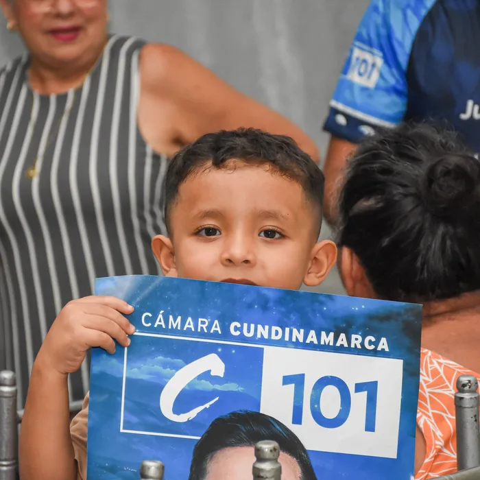 Un niño sostiene el cartel Cámara Cundinamarca C101