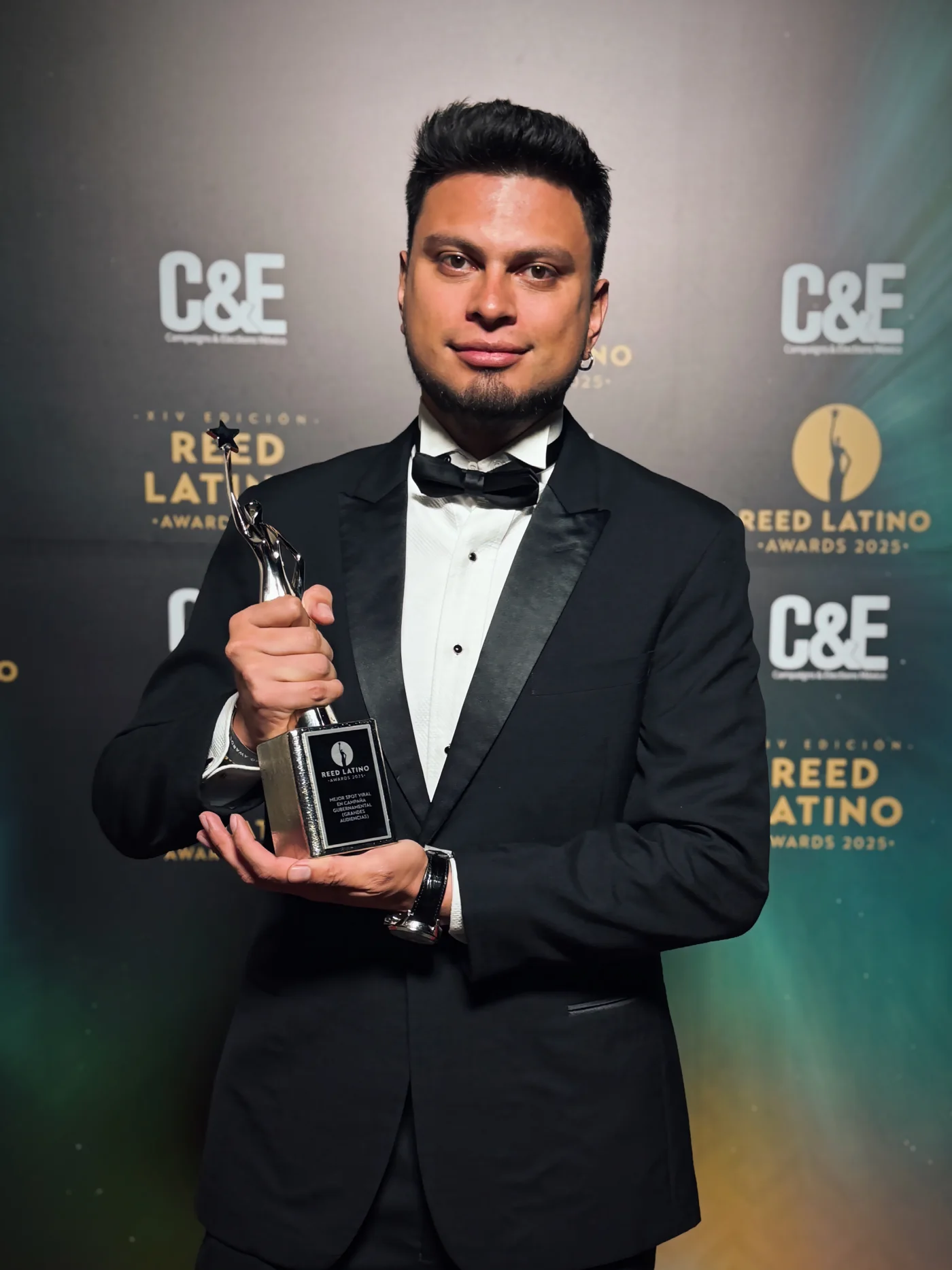 Sebastián Díaz de esmoquin con la estatuilla del Reed Latino Awards 2025